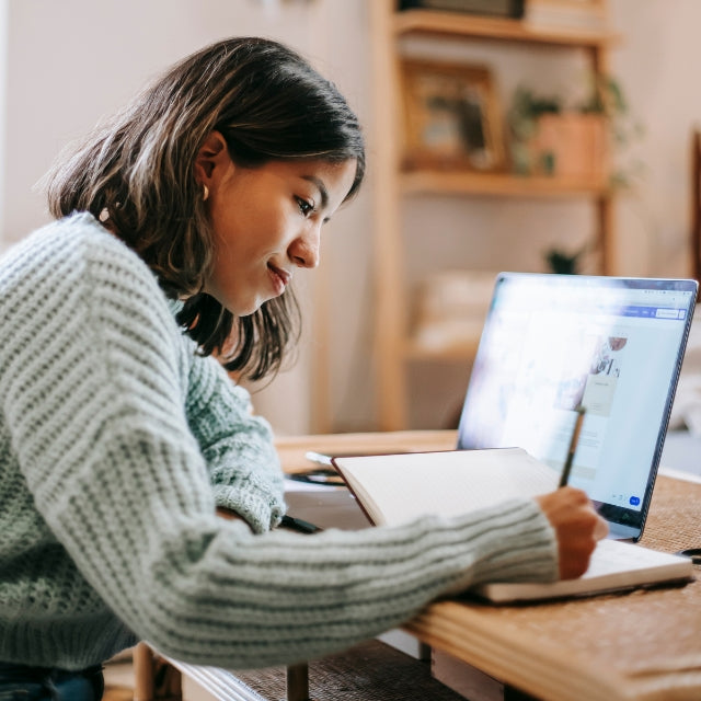 Fille qui travaille sur son bureau et écrit sur son cahier